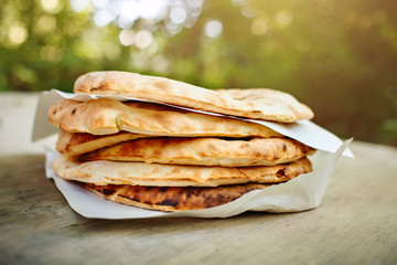A stack of pita bread on a wooden table .