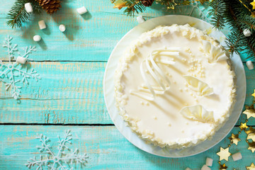 Obraz na płótnie Canvas Birthday cake with white chocolate icing on a festive Christmas table. Top view.