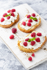 Breakfast slice of bread with Ricotta cheese served with raspberries