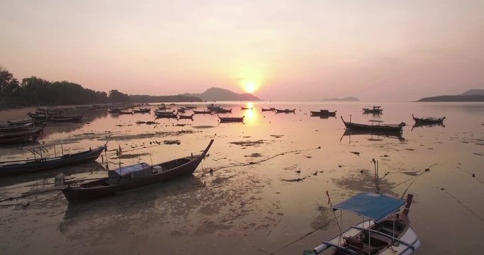 Ascending Drone Shot of Sunset Over Thai Long-tail Boats in Phuket Thailand
