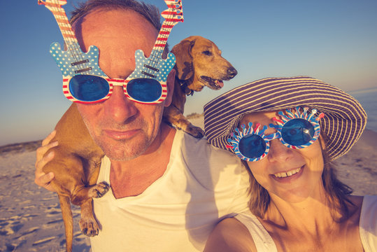 Cheerful couple with a little dog taking selfie