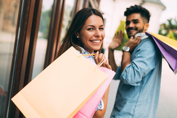 Happy attractive loving couple enjoy shopping together