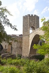Obraz premium bridge and a tower made of stone over a river, Spain