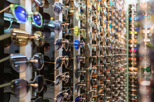 Display in store with different eyewear models -  eye glasses on the shelf background.