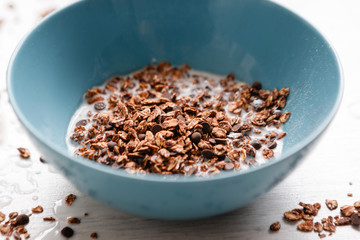Healthy cereal breakfast. Sweet granola in teal bowl closeup on white background. Wholegrain vegetarian morning tasty food.