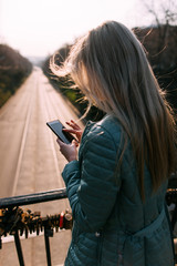 Naklejka na ściany i meble Bad news on mobile phone. Girl with gadget. Female on street rear view, modern social media technology