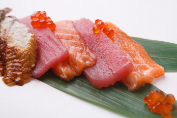 Sashimi set on bamboo leaf isolated at white, closeup