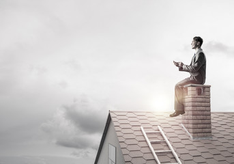 Businessman or student on brick roof smiling and making calls