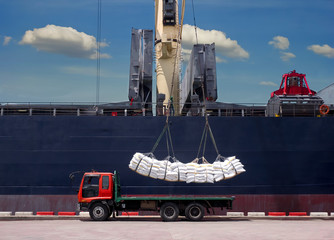 Sugar bags are loading in hold of bulk-vessel at industrial port,Pick up sugar bags from truck to ...