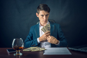 Man Businessman in suit puts money in his pocket. A bribe in the form of dollar bills. Concept of corruption and bribery
