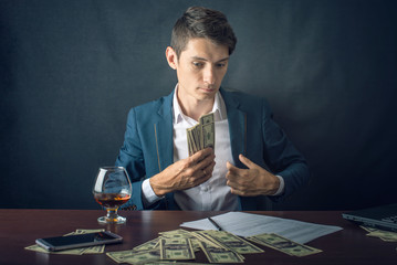 Man Businessman in suit puts money in his pocket. A bribe in the form of dollar bills. Concept of...