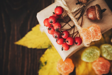 Gift box with autumn decorations on wooden background. Top view.Close up