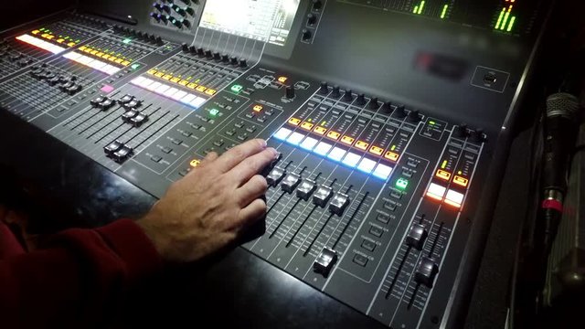 Professional audio mixing console with faders and adjusting knobs - 