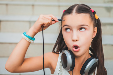 little child with headphones holding the plug