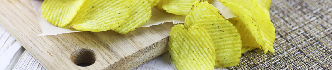 Horizontal bakground of potato chips on a table