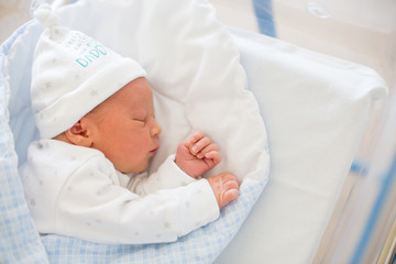 Newborn baby laying in crib in prenatal hospital