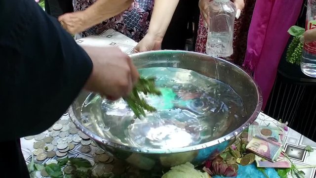 Pot with holy water for pray. People are taking some 