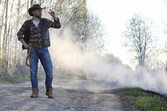 A cowboy in a thick smoke on the road