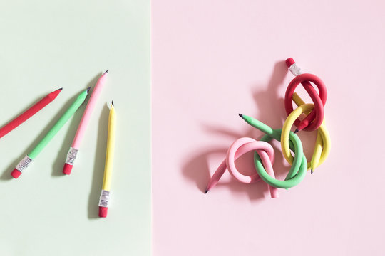 Individual and linked flexible pencils arranged on colorful paper