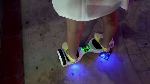 Feet of girl riding on modern electric mini segway hoverboard 