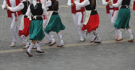 Grupo de personas con el traje tradicional vasco bailando en la calle durante un festival de verano