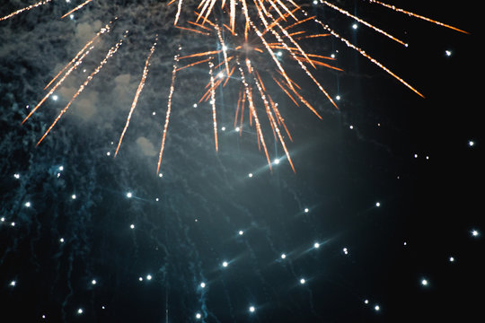 Fireworks explode in the night sky.
