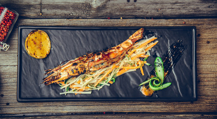 Appetizers grilled shrimp with parsley lemon slice, on a wooden background