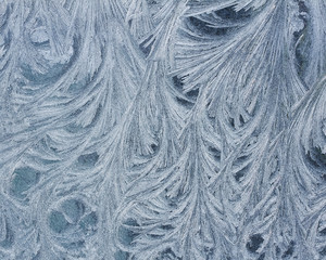 beautiful holiday background of intricate frosty pattern on glass