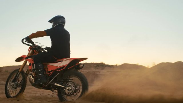 Professional Motocross Biker Drives on the Off-Road Sand Track on his Motorcycle. Shot on RED EPIC-W 8K Helium Cinema Camera.