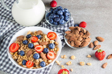 Healthy breakfast concept with oat flakes and fresh berries on rustic background. Food made of granola, muesli. Healthy banana smoothie with blackberries, muslie, strawberries, blueberries and honey.