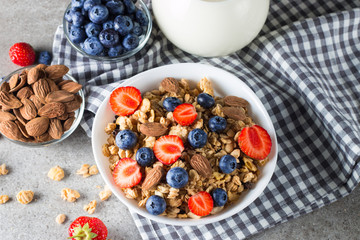 Healthy breakfast concept with oat flakes and fresh berries on rustic background. Food made of granola, muesli. Healthy banana smoothie with blackberries, muslie, strawberries, blueberries and honey.