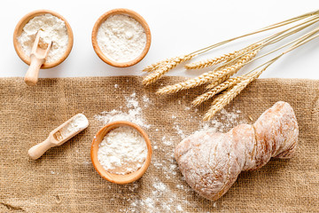 fresh bread with wheat flour in bakery shop on white desk background top view