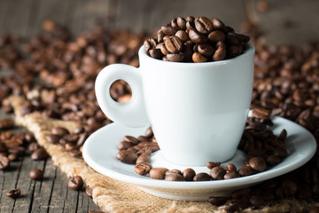 A white set of coffee on wooden and sacking background with cinnamon and coffee beans