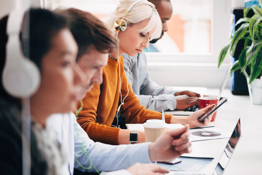 Group of young professional business people students working on technology listening to music studying