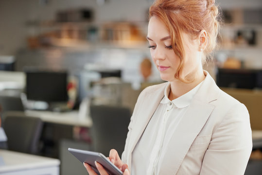 Businesswoman using digital tablet touchscreen in trendy office
