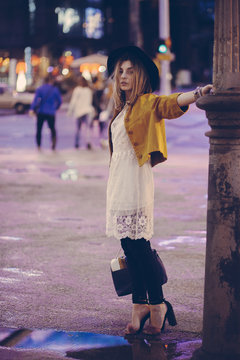 Beautiful fashionable woman walking on the streets at night