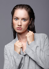 Beauty portrait of young woman in gray dress. Brunette girl with bright blue eyes and day female makeup
