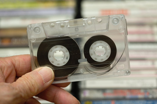 Hand holding cassette tape made of clear plastic