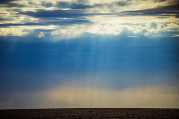 Crepuscular rays falling on dry gound in the desert / outback of Australia.