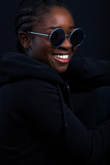 Obraz premium Woman Wearing Sunglasses While Smiling Over Black Background