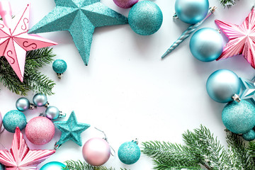 Christmas decoration frame. Pink and blue stars and balls near pine branches on white background top view copyspace