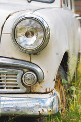 The old rusted machine. Front view where there is a spotlight with a grille and a bumper