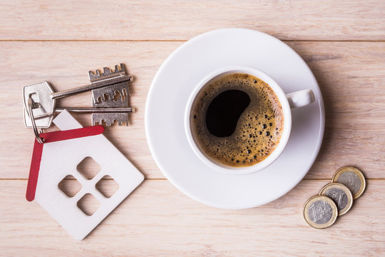 Top view of coffee cup and house model with keys