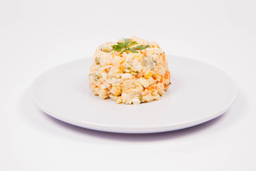 Vegetable salad (potato, carrot, corn, pea, egg, leek) with mayonnaise on a white background