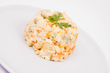 Vegetable salad (potato, carrot, corn, pea, egg, leek) with mayonnaise on a white background