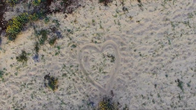 coeur d&eacute;ssin&eacute; sur le sable d'une plage 