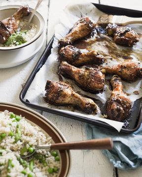 Delicious grilled chicken legs with bowl of rice with peas