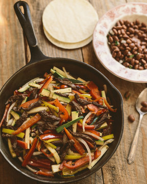 Close-up of flank steak fajitas with beans and vegetables