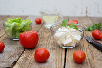 Ingedients for healthy salad consisting of lettuce, tomatoes and cheese