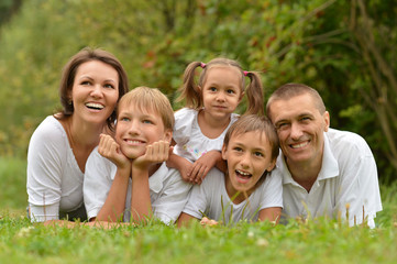 Fototapeta premium family lying on green grass 